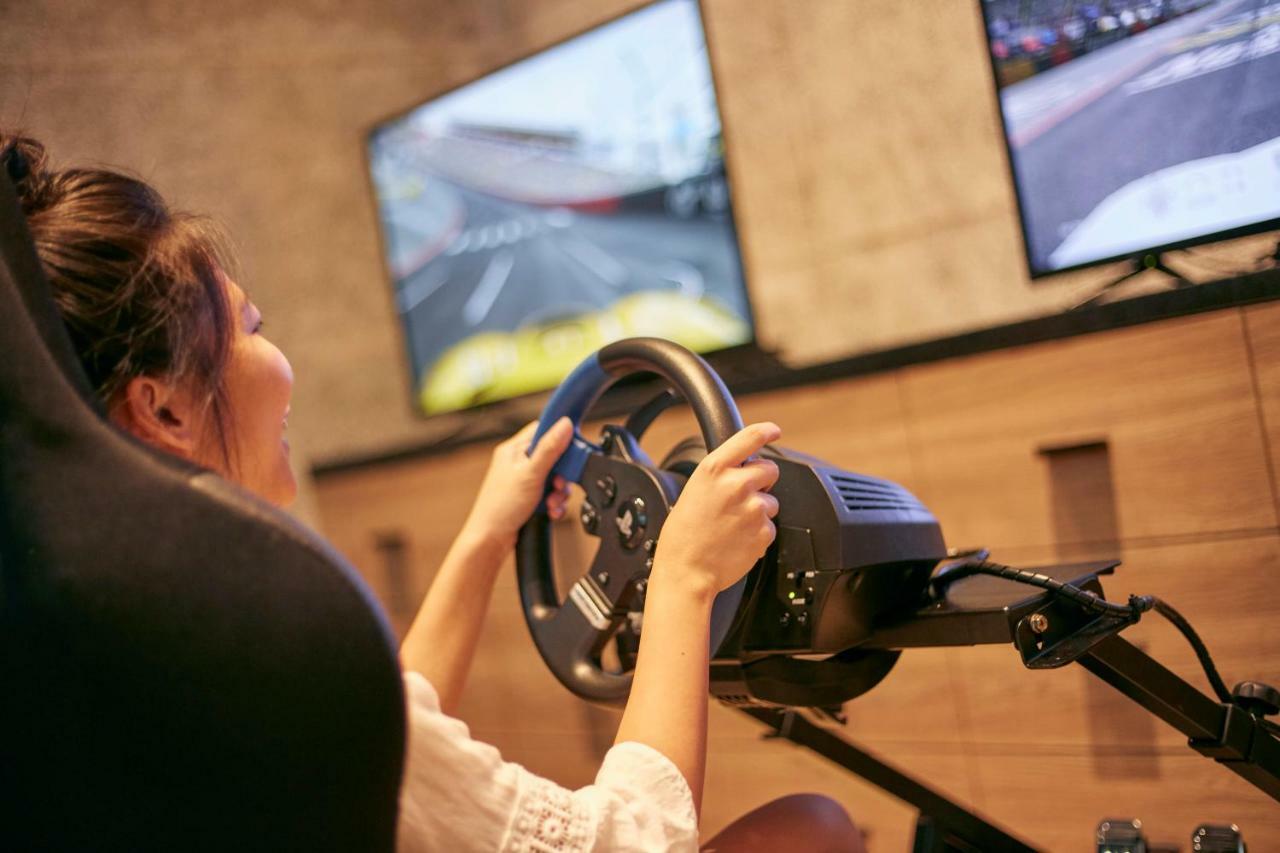 Mu Jiaoxi Hotel Exteriör bild A woman playing a racing video game
